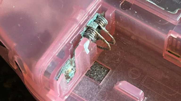 Severely corroded gameboy that won't turn on and battery contacts with blue and white crust buildup.